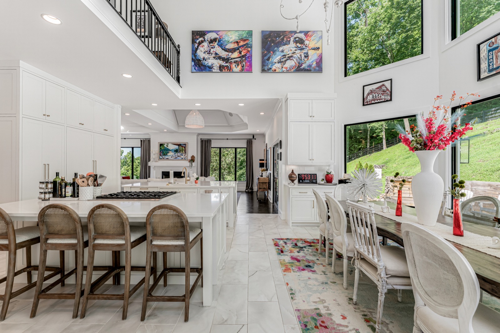 The chef's kitchen and its entertaining layout: marble island, a wall of windows to the grounds.